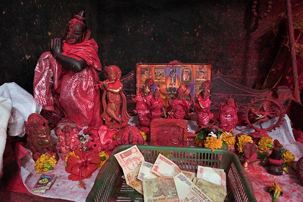 Small statues of Hindu deities and donation basket, Navagraha Temple